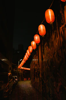 A mysterious nighttime scene with glowing lanterns and shadowy figures in a Seoul alley.