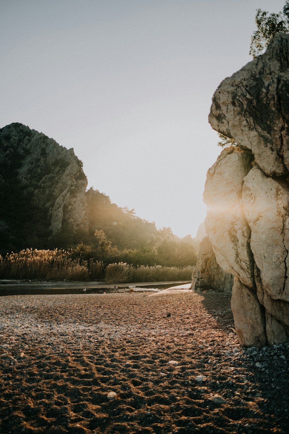 a person standing on a rocky beach next to a body of water