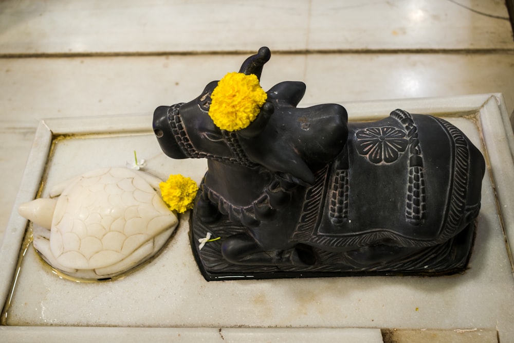 a statue of a cow and a turtle on a tile floor