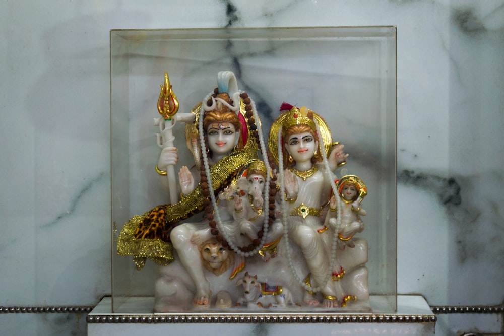 a group of statues of hindu deities in a glass case
