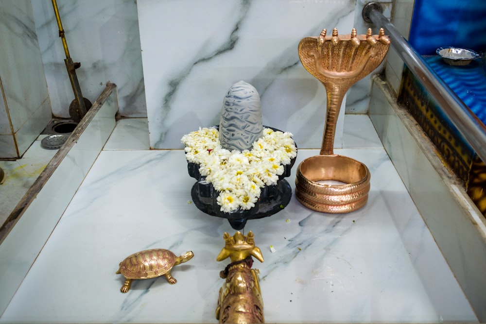 a bathroom with a marble counter top and gold accessories