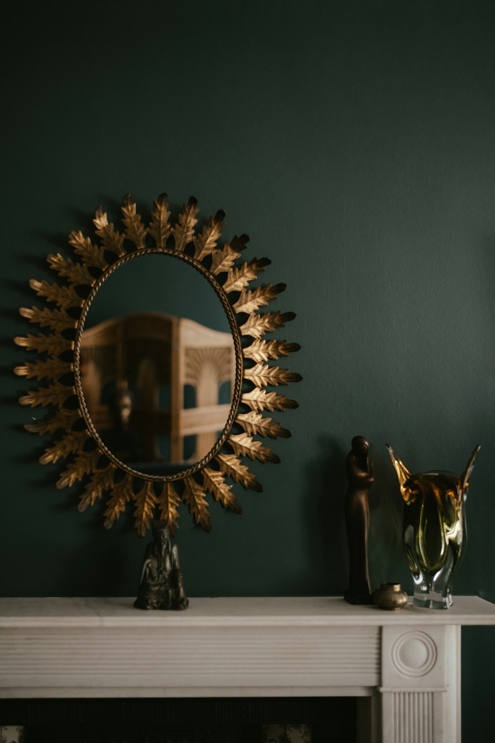 a fireplace with a mirror and vase on top of it