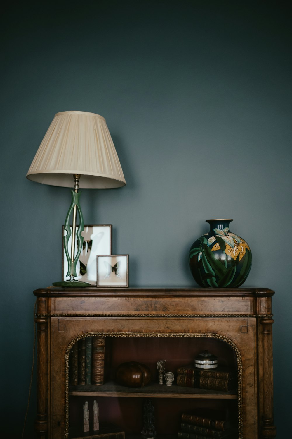 a table with a lamp and a vase on top of it