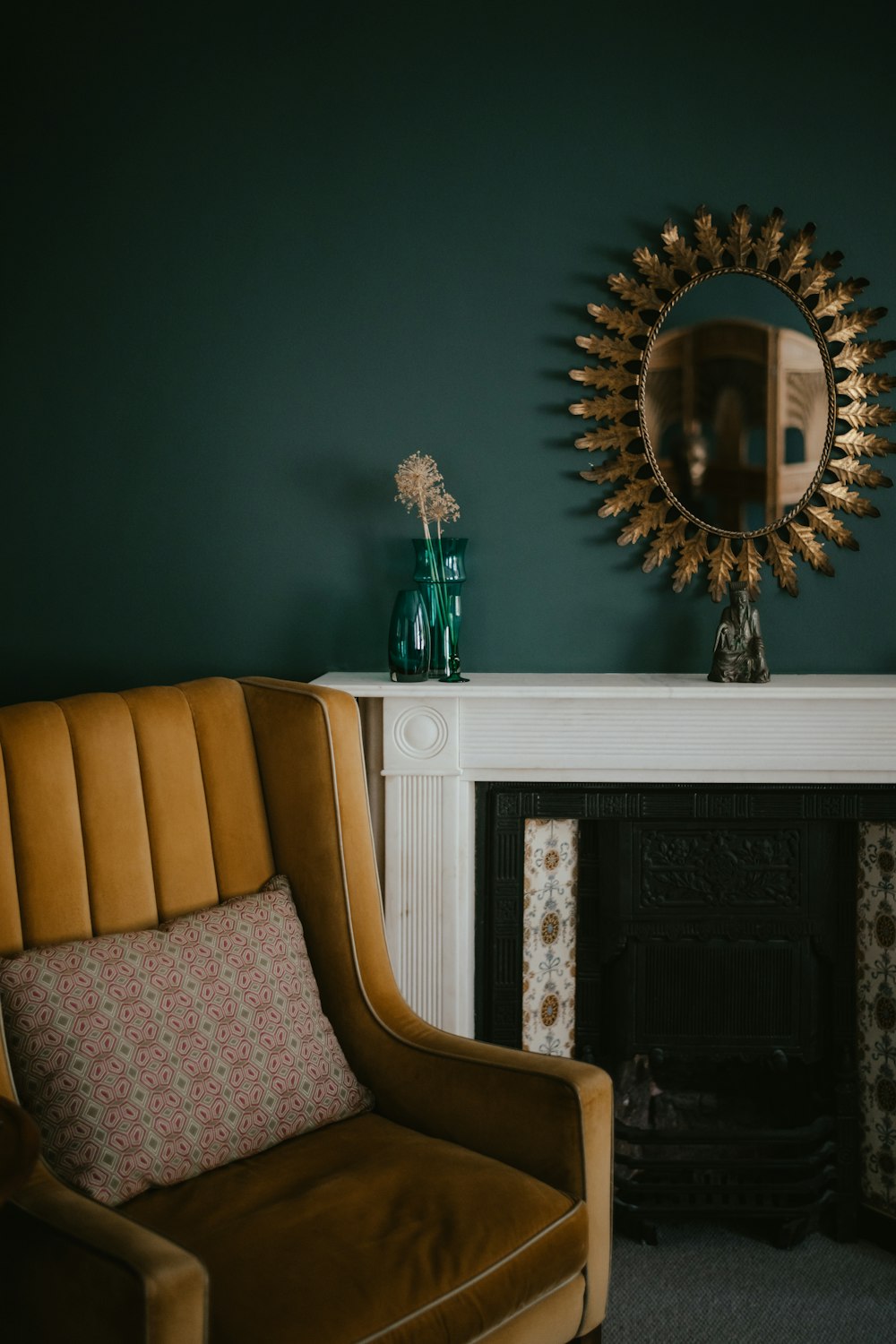 a living room with a chair, mirror and fireplace