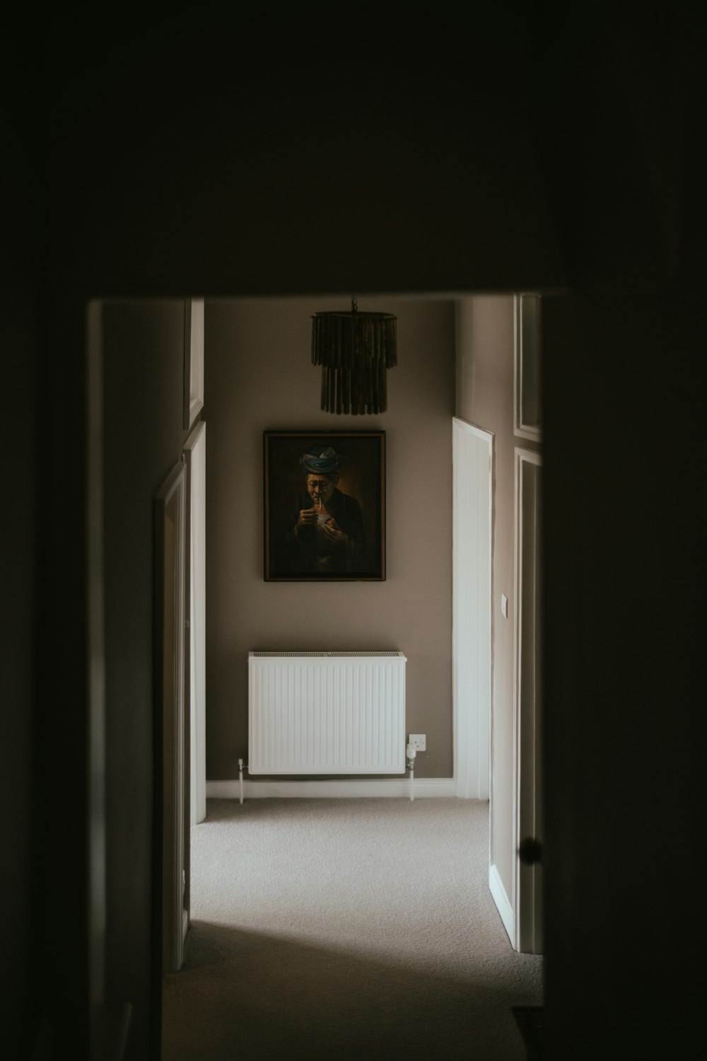 a hallway with a radiator and a painting on the wall