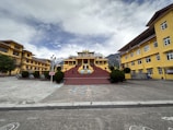 a yellow building with a red staircase in front of it