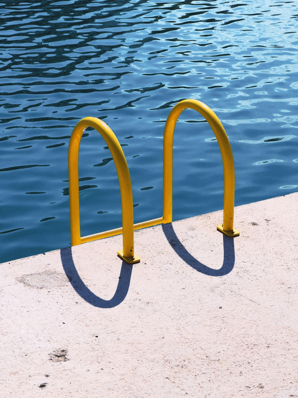 a pair of yellow bars sitting next to a body of water