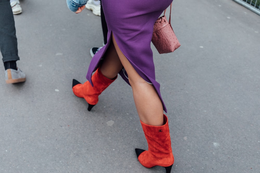 a woman in a purple dress and orange boots