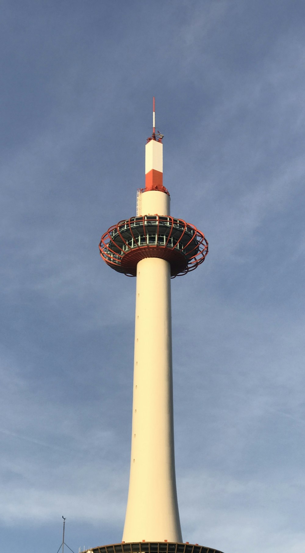 ein hoher Turm mit rot-weißer Spitze