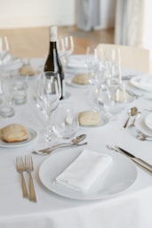 a table set with a bottle of wine and silverware