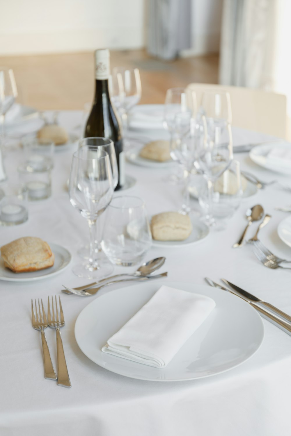 a table set with a bottle of wine and silverware