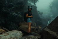 a woman standing on top of a large rock