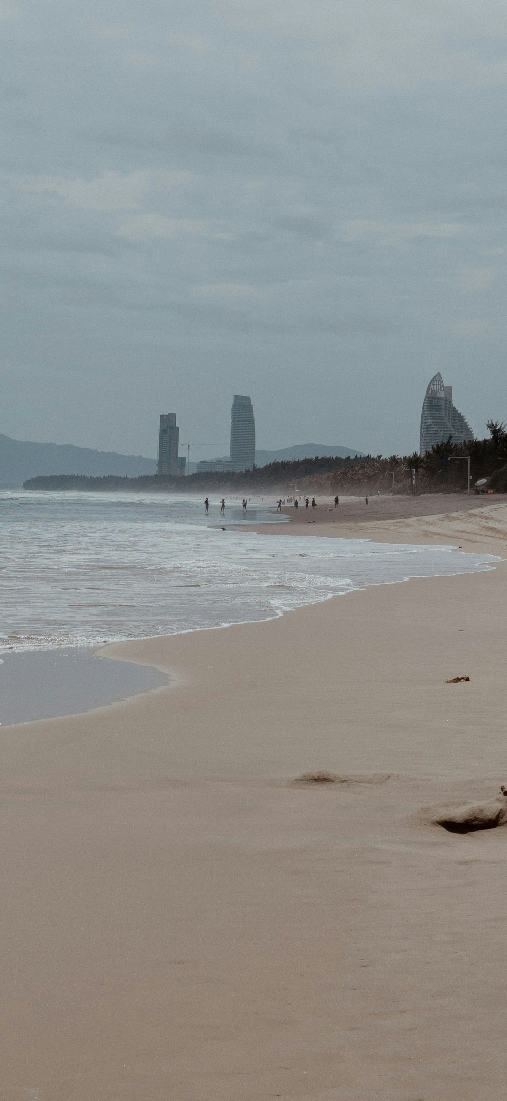 a beach with a few people walking on it