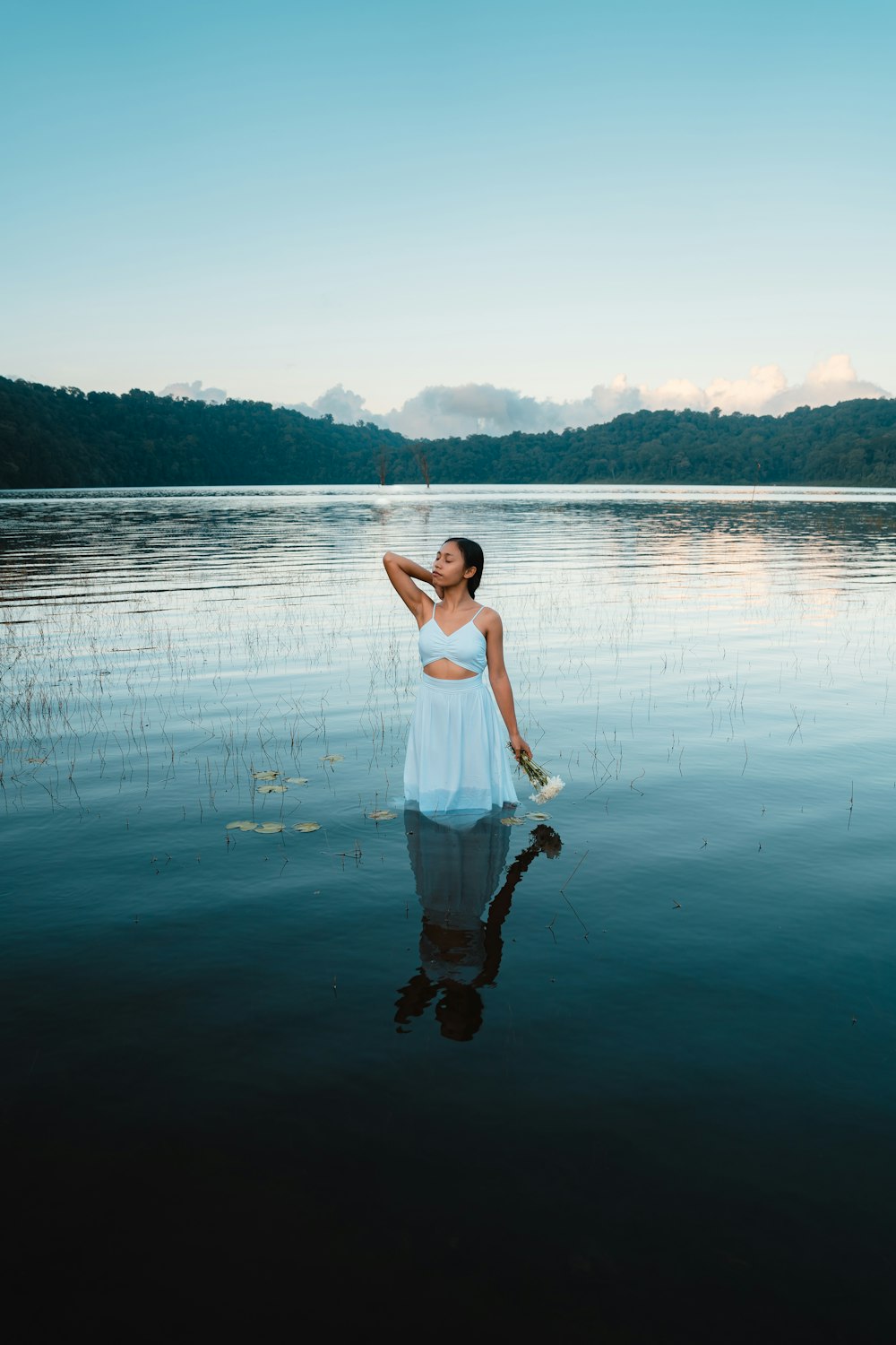 a woman in a white dress standing in the water