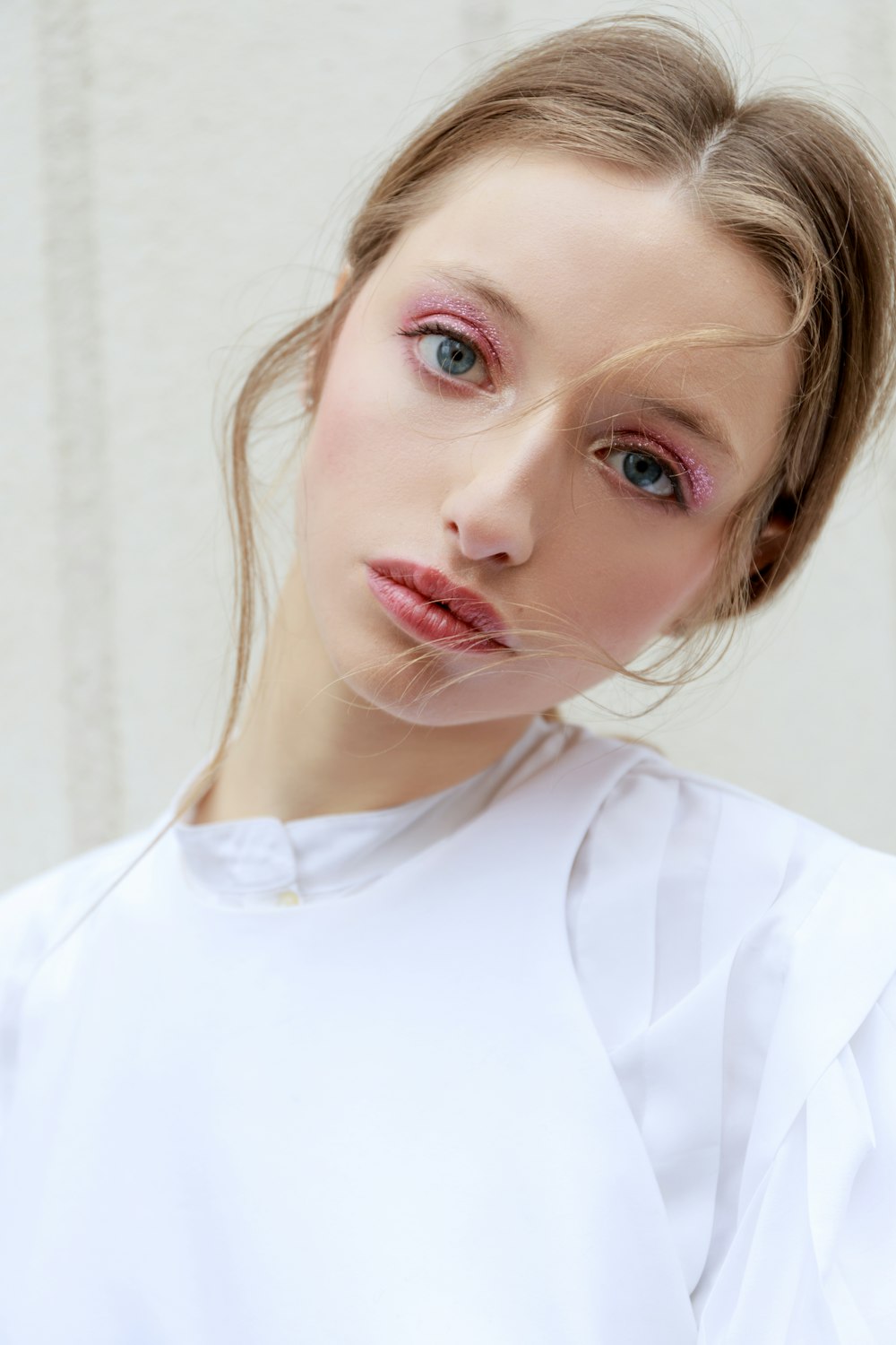 a woman with a pink eyeliner and a white shirt