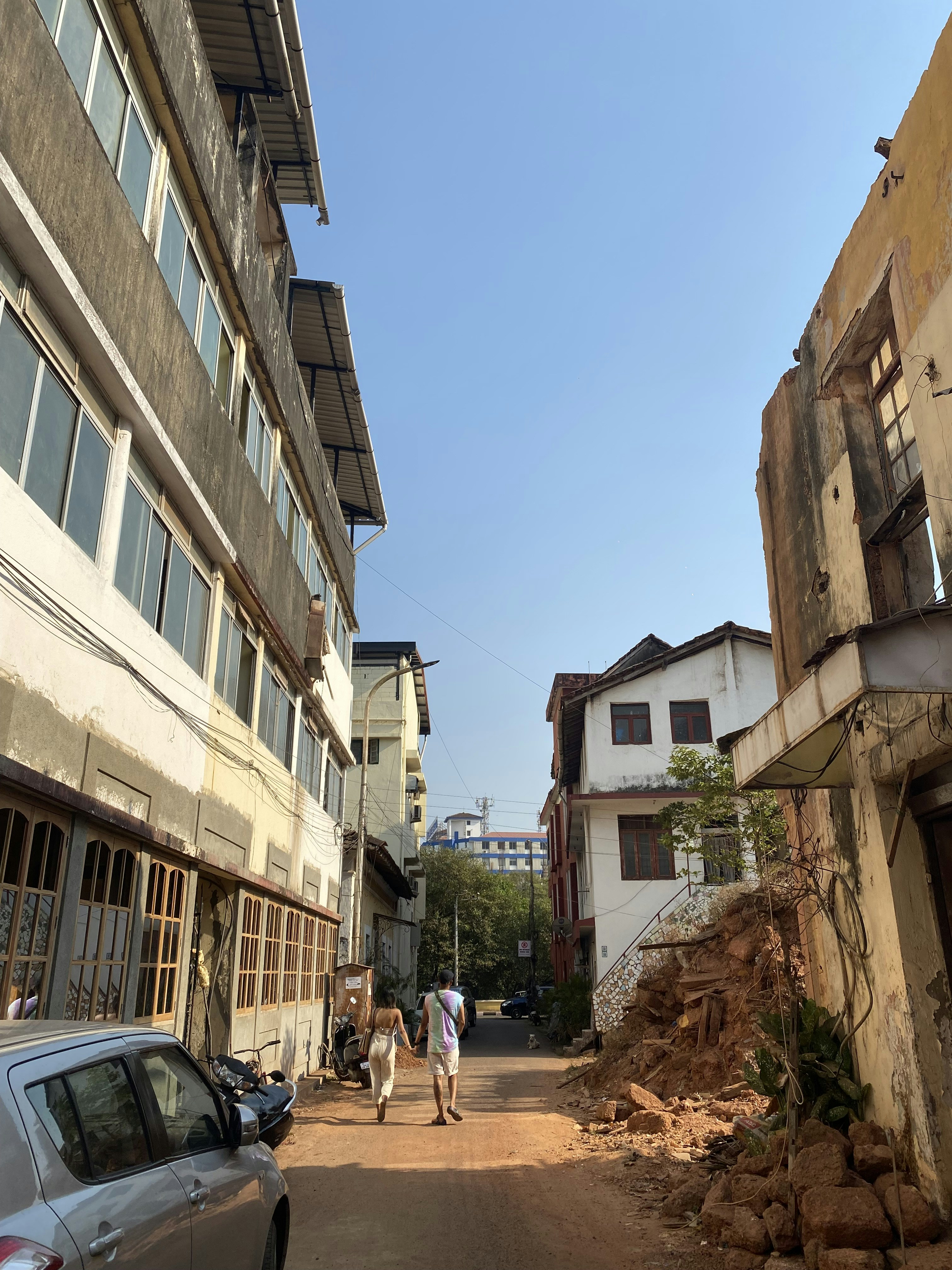 a couple of people walking down a dirt road