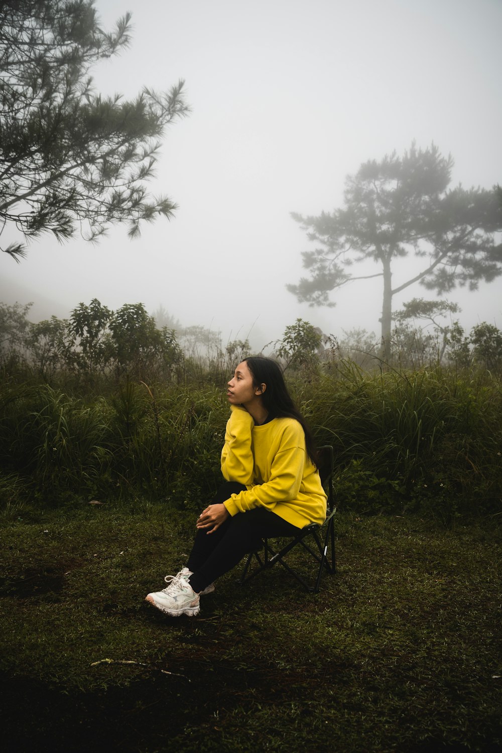 a woman in a yellow jacket sitting in a chair