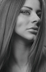 Close-up black-and-white portrait of a model with striking makeup.