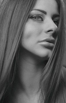 Close-up black-and-white portrait of a model with striking makeup.