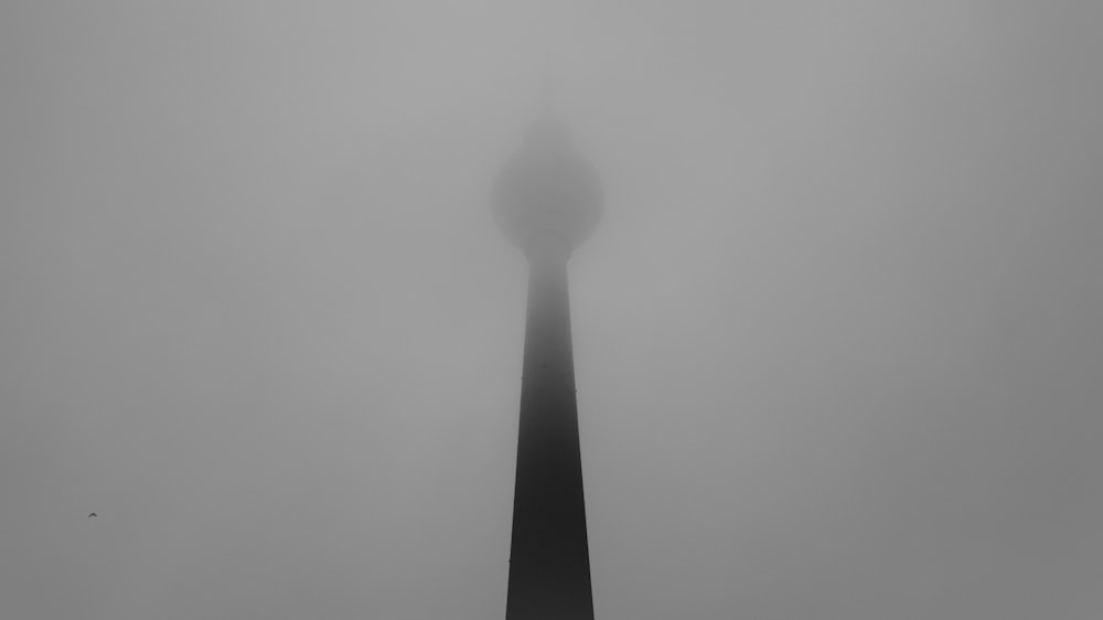 a tall tower in the middle of a foggy sky