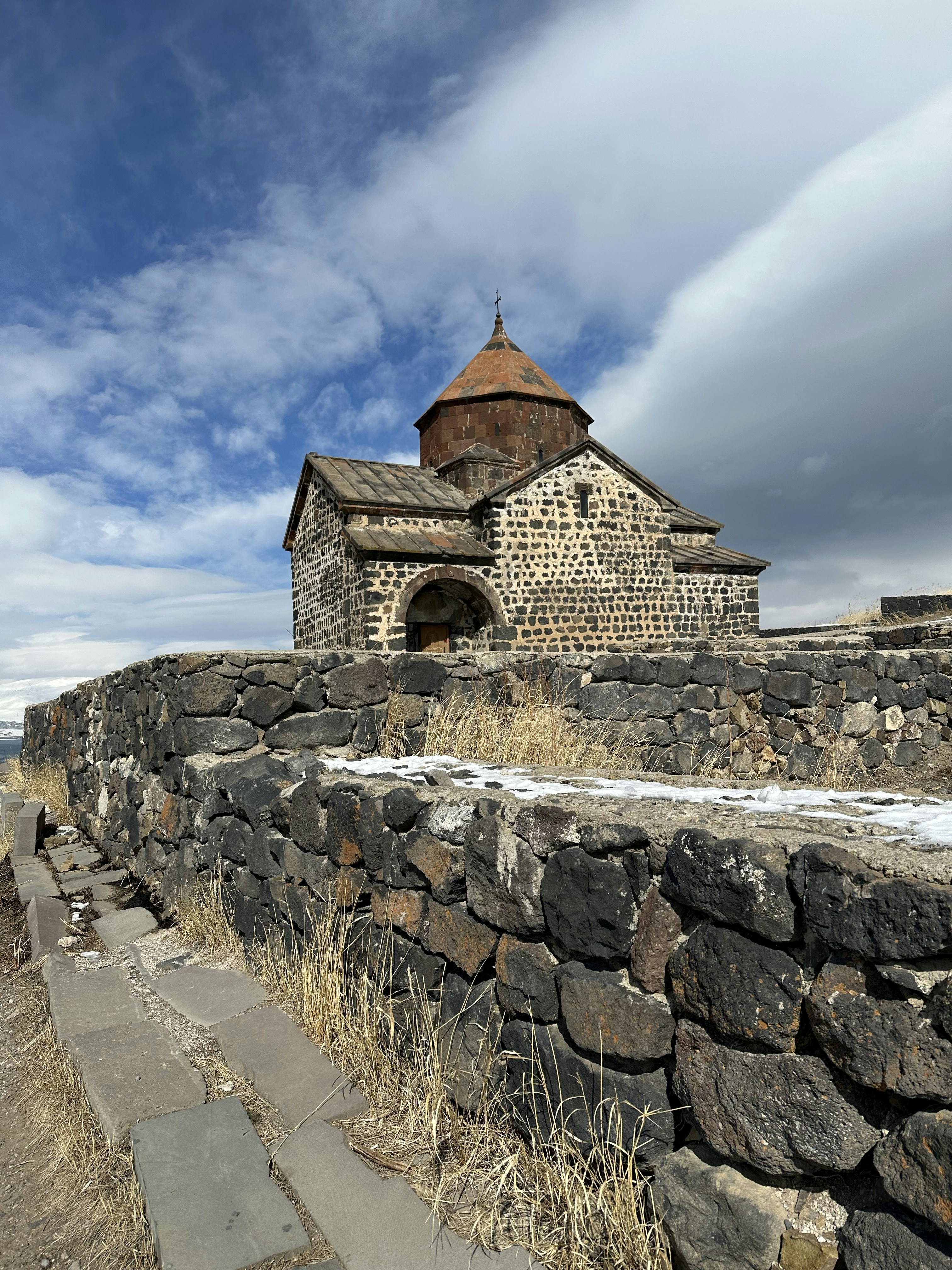 a stone wall with a building on top of it