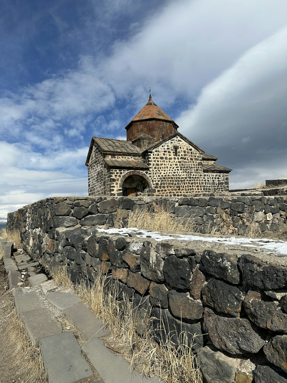 a stone wall with a building on top of it