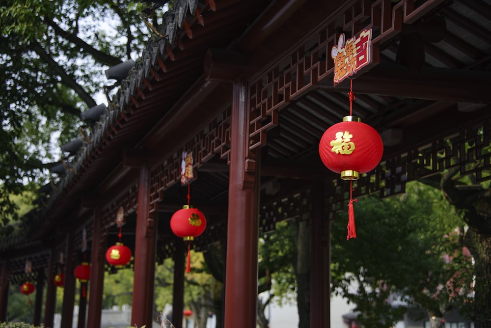 a row of red lanterns hanging from a wooden structure