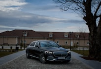 Wide shot of a sleek driveway paved with dark, polished cobblestones at sunset