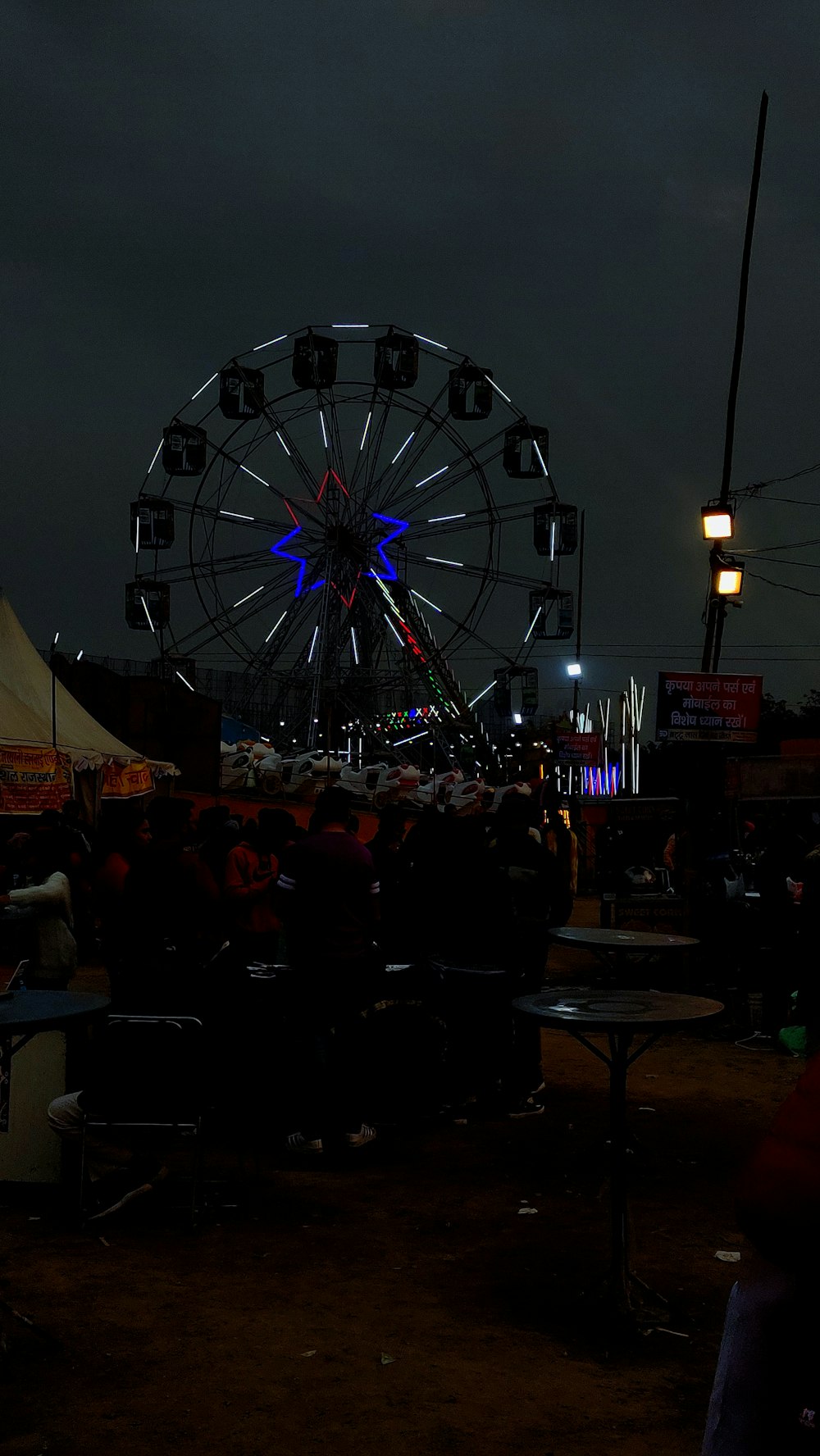 a large ferris wheel sitting next to a crowd of people