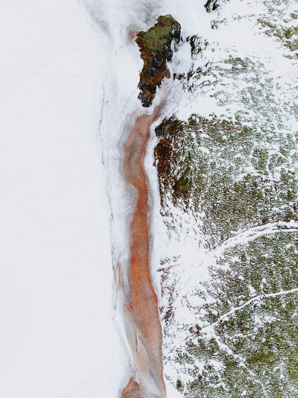 an aerial view of a body of water covered in snow