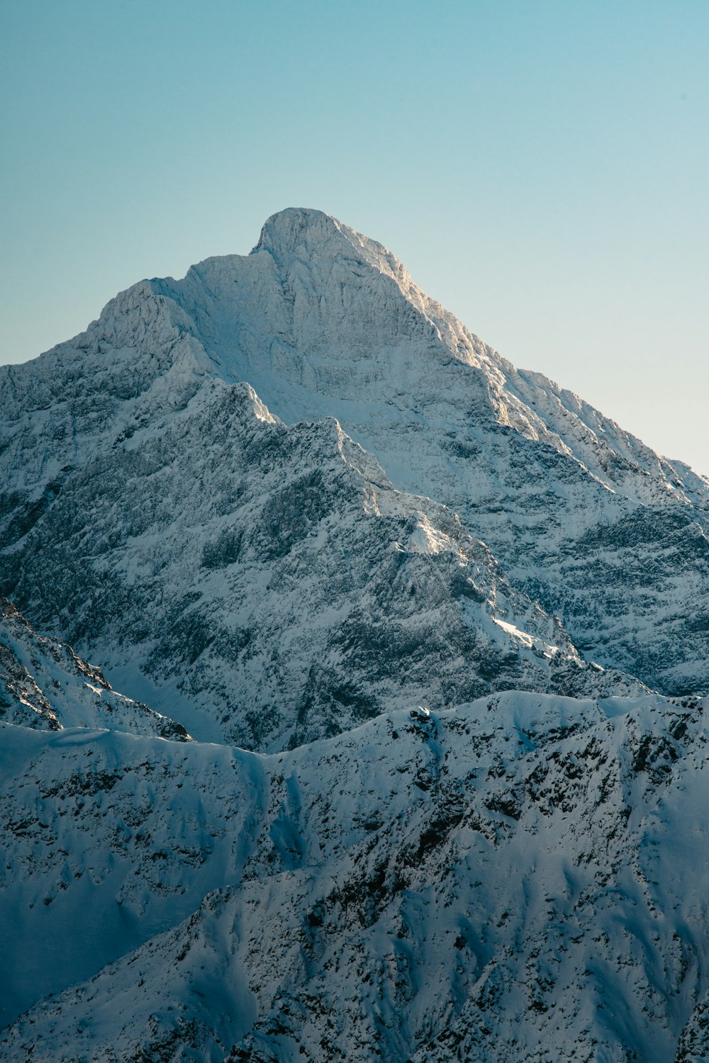 a mountain covered in snow under a blue sky