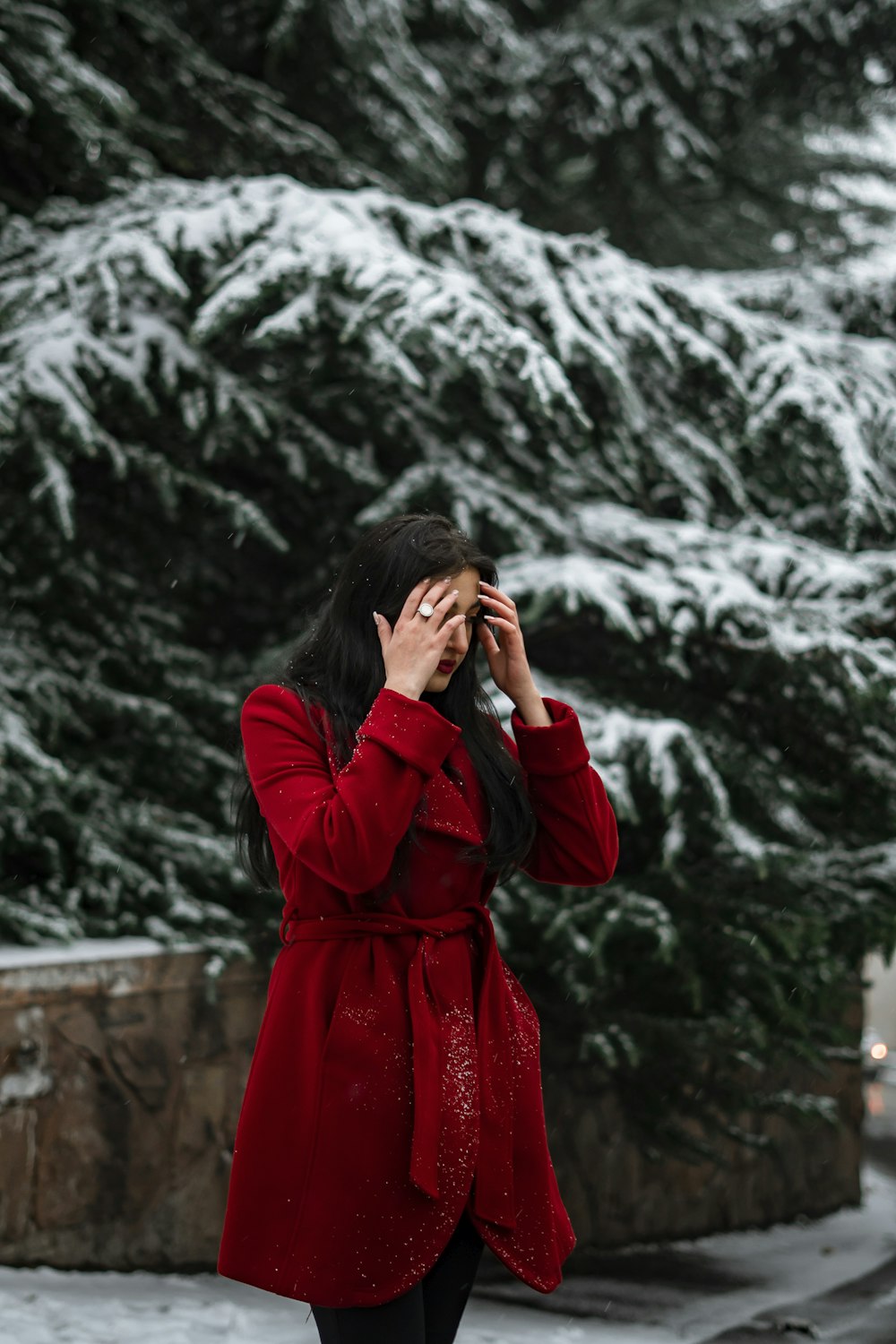 a woman in a red coat talking on a cell phone