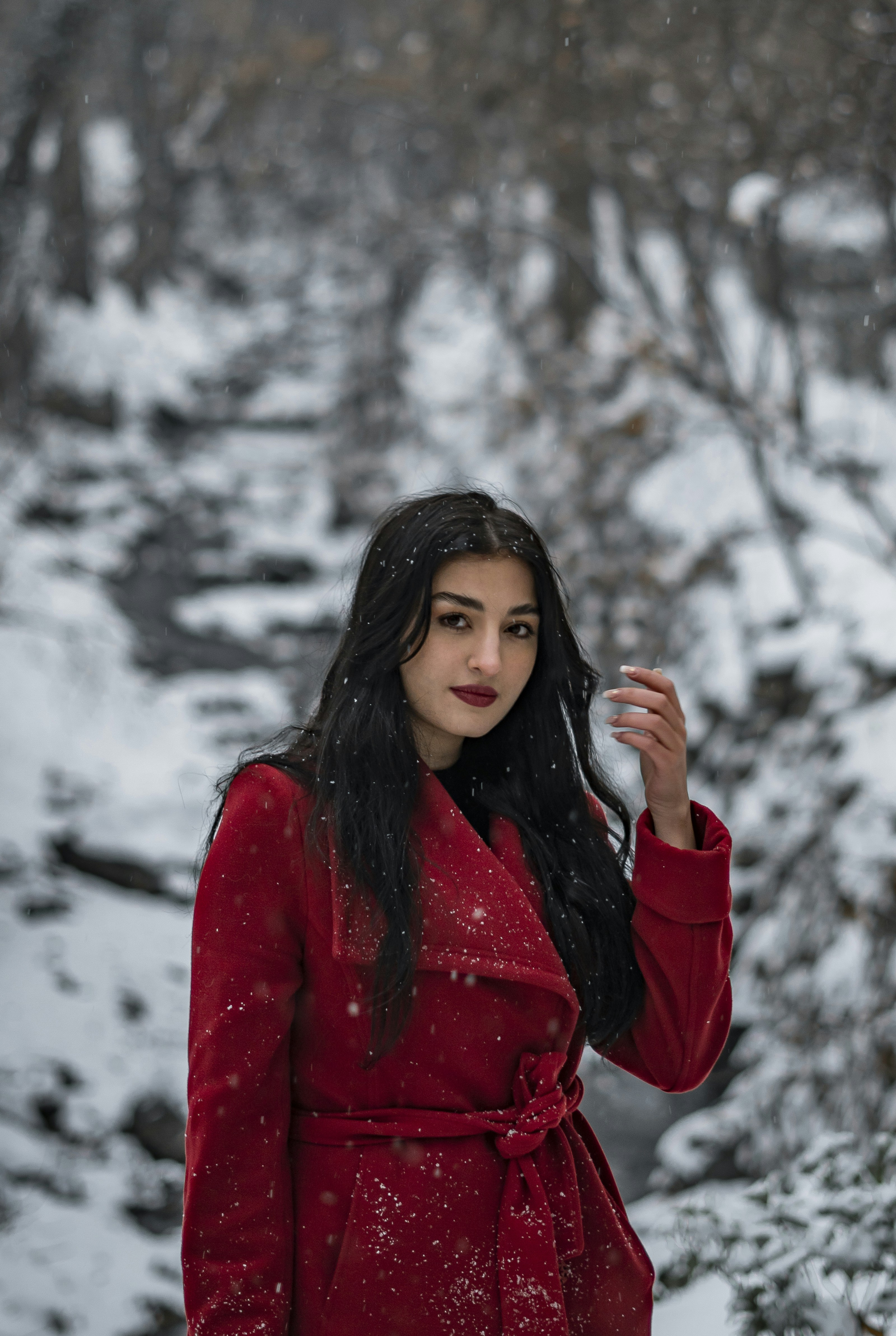 a woman in a red coat standing in the snow