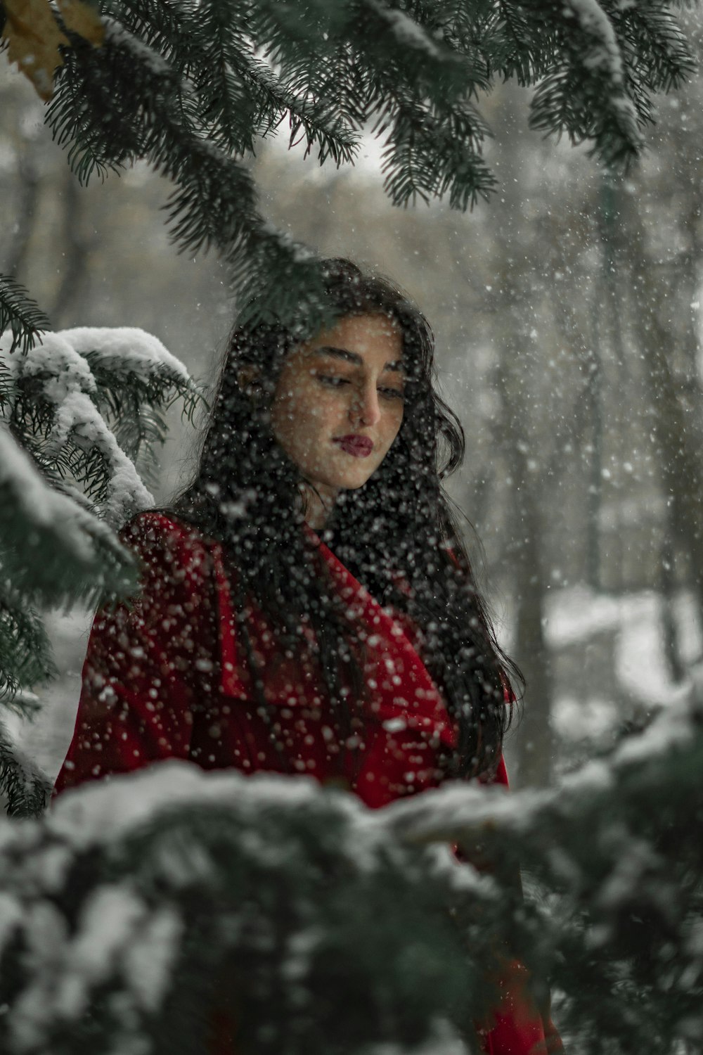 a woman in a red coat standing in the snow