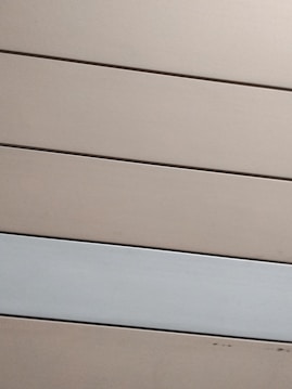 Horizontal panels with a matte finish are arranged in parallel. The panels are mostly beige with one grayish-white panel standing out against the rest.