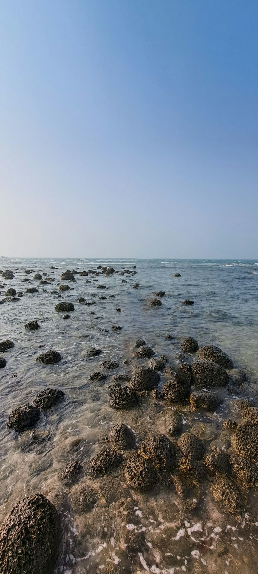 a view of the ocean with rocks in the water