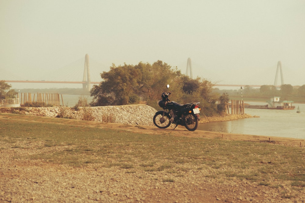 a motorcycle parked on the side of a road next to a body of water