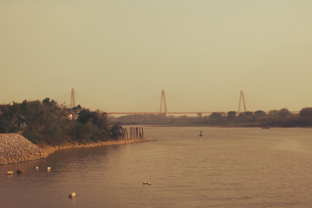 a body of water with a bridge in the background