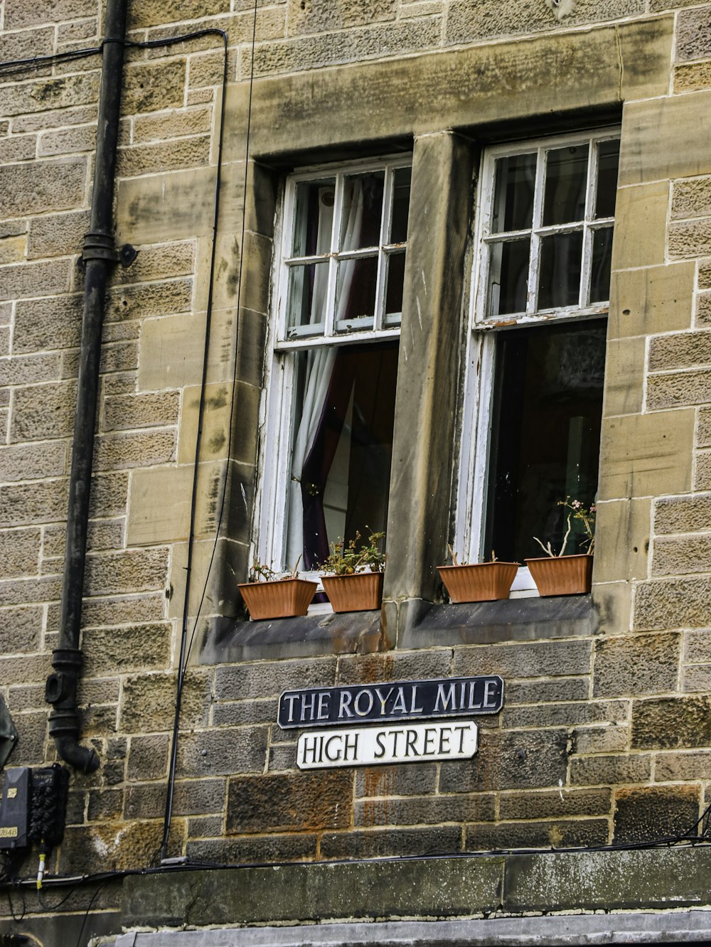 a brick building with two windows and a sign that says royal mile high street