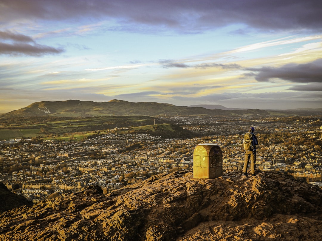 a man standing on top of a large rock,