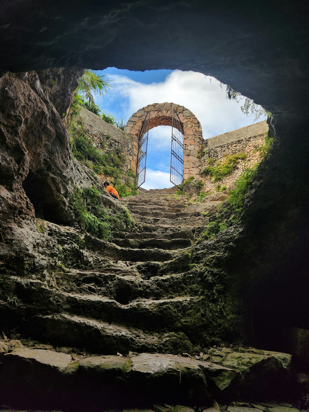 a view of a stone staircase through a cave