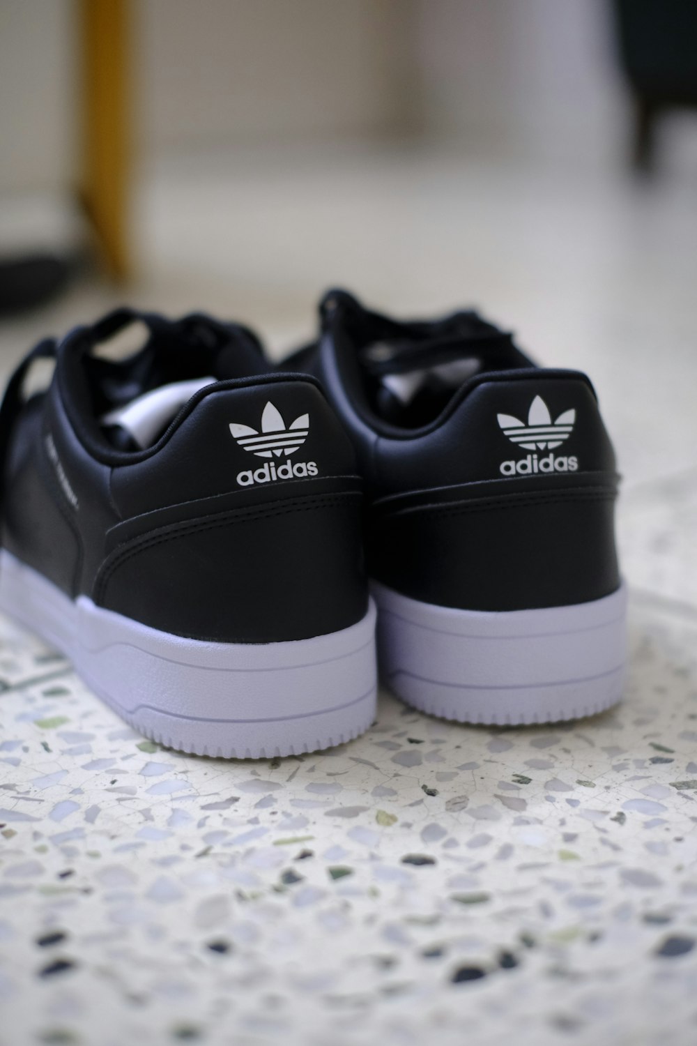 a pair of black and white adidas sneakers