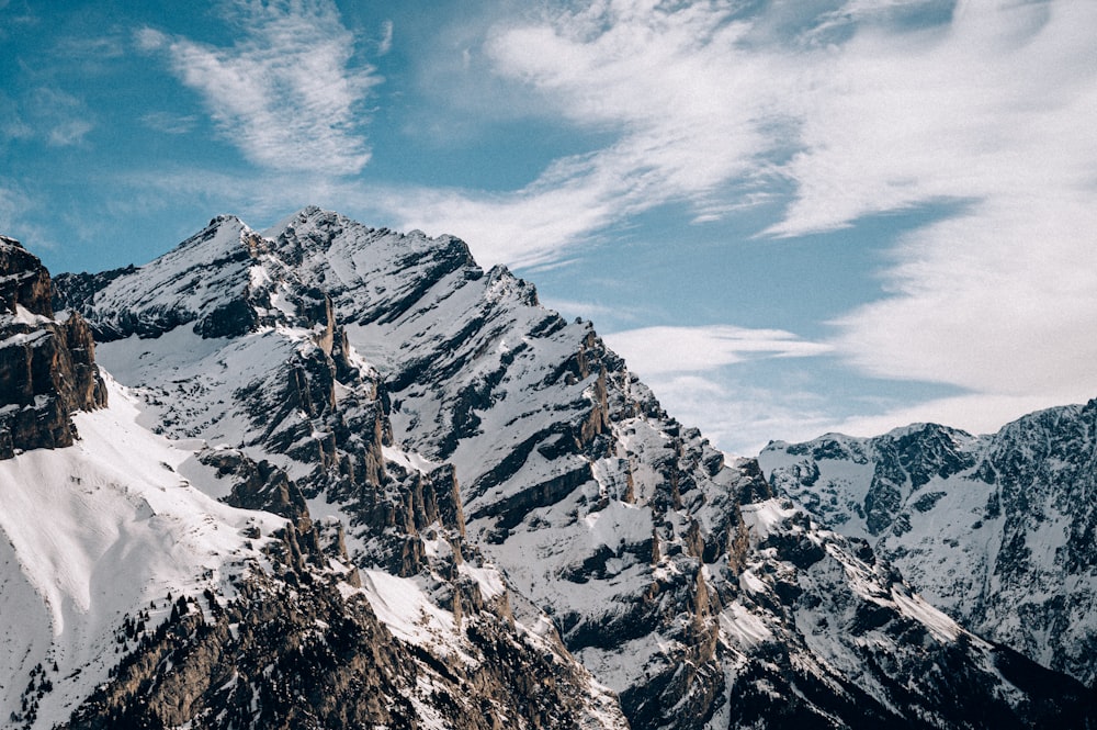 a snow covered mountain range under a blue sky