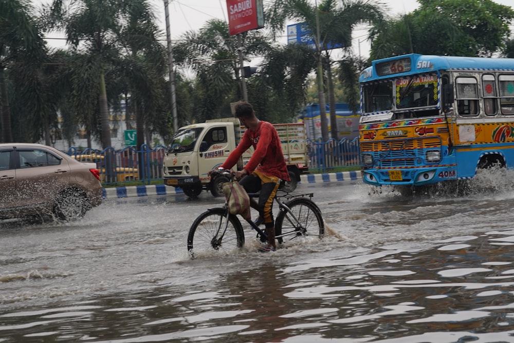 a man riding a bike through a flooded street