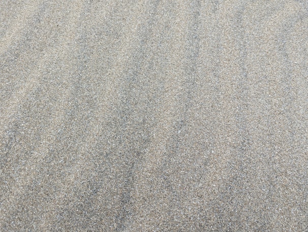 Fine plastering sand being used in sandblasting to clean a metal surface with light rust.