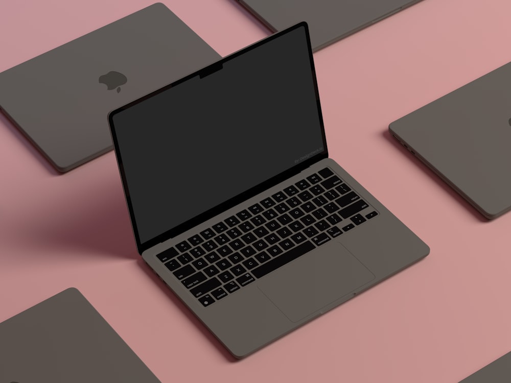 분홍색 표면 위에 앉아있는 노트북 컴퓨터