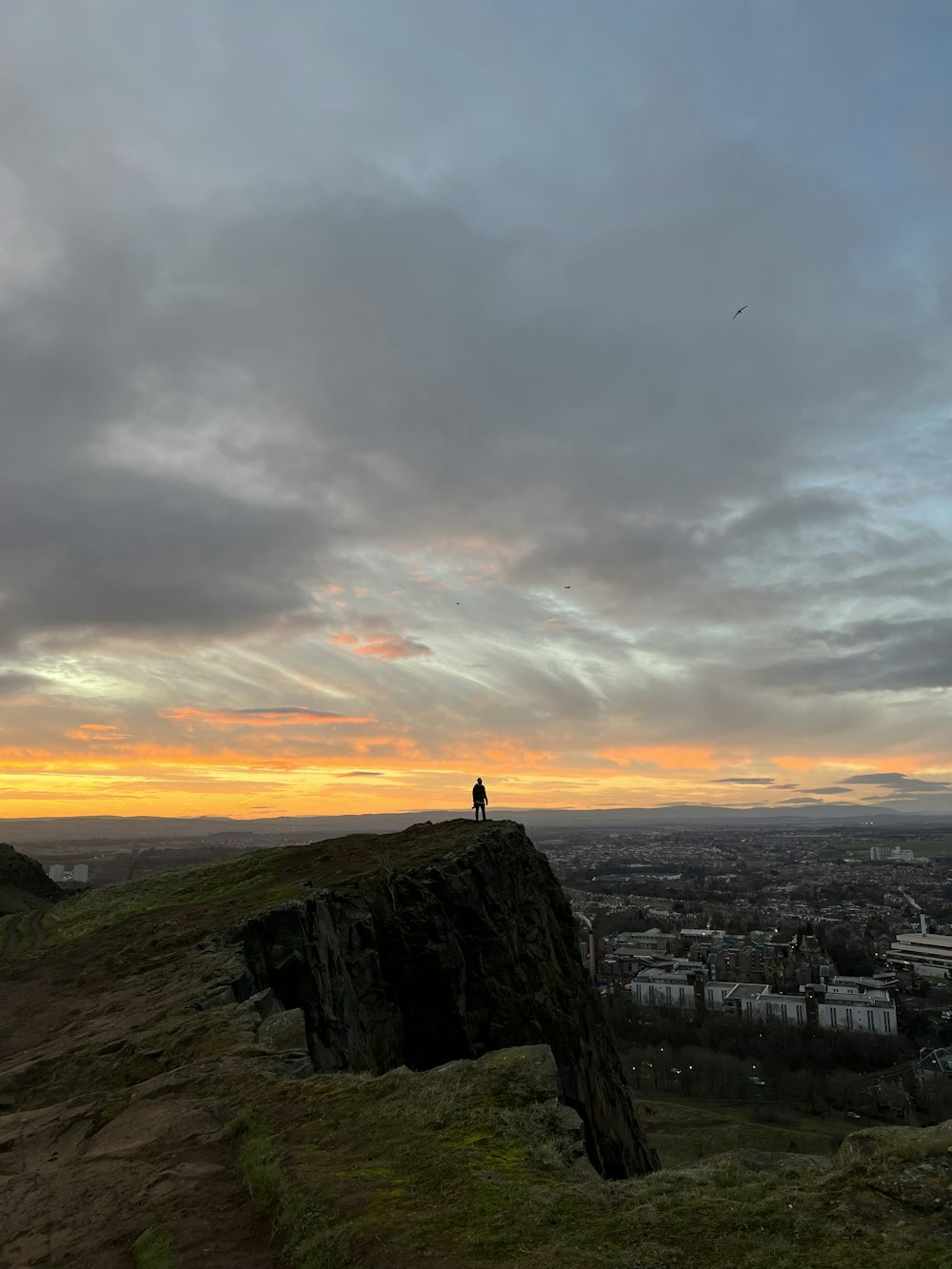 a person standing on top of a hill overlooking a city