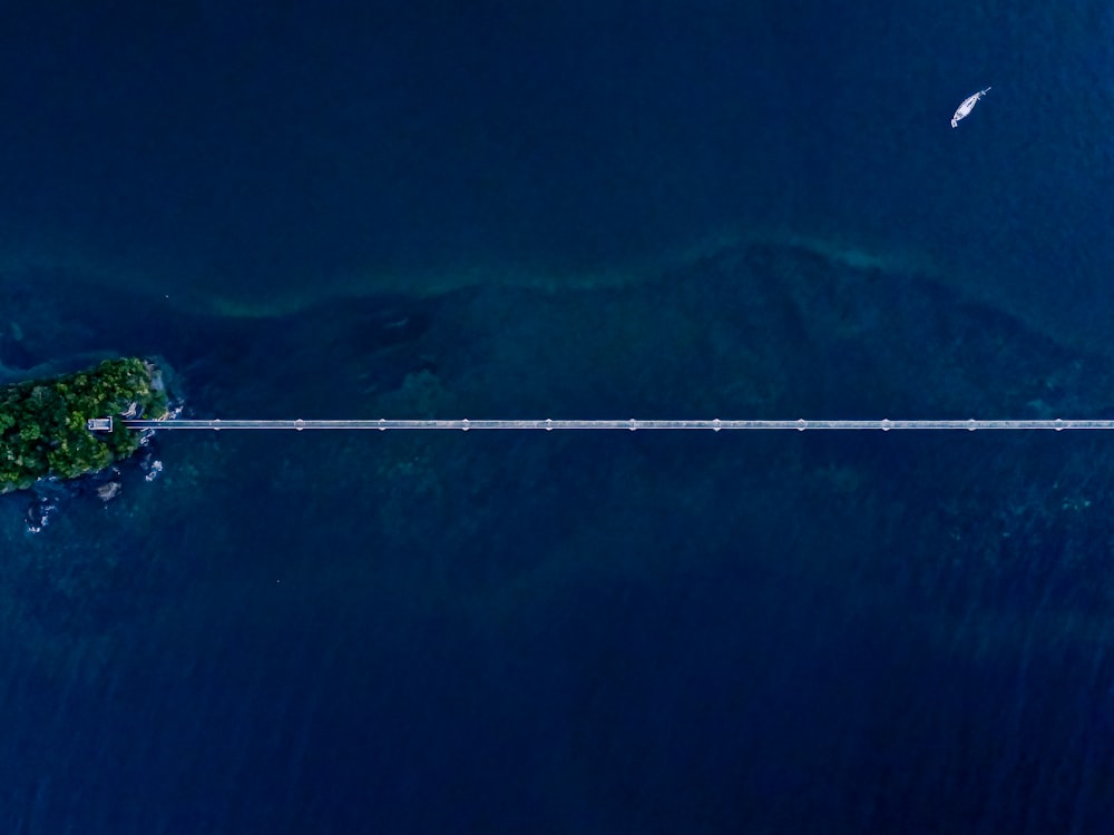 an aerial view of the ocean with a boat in the distance