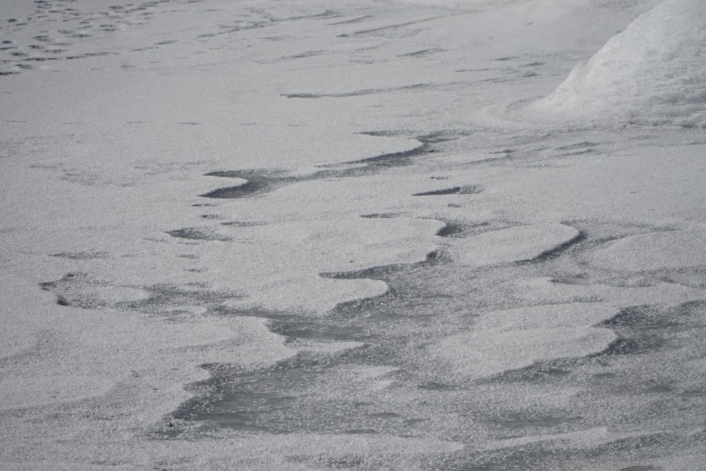 a snow covered ground with footprints in the snow