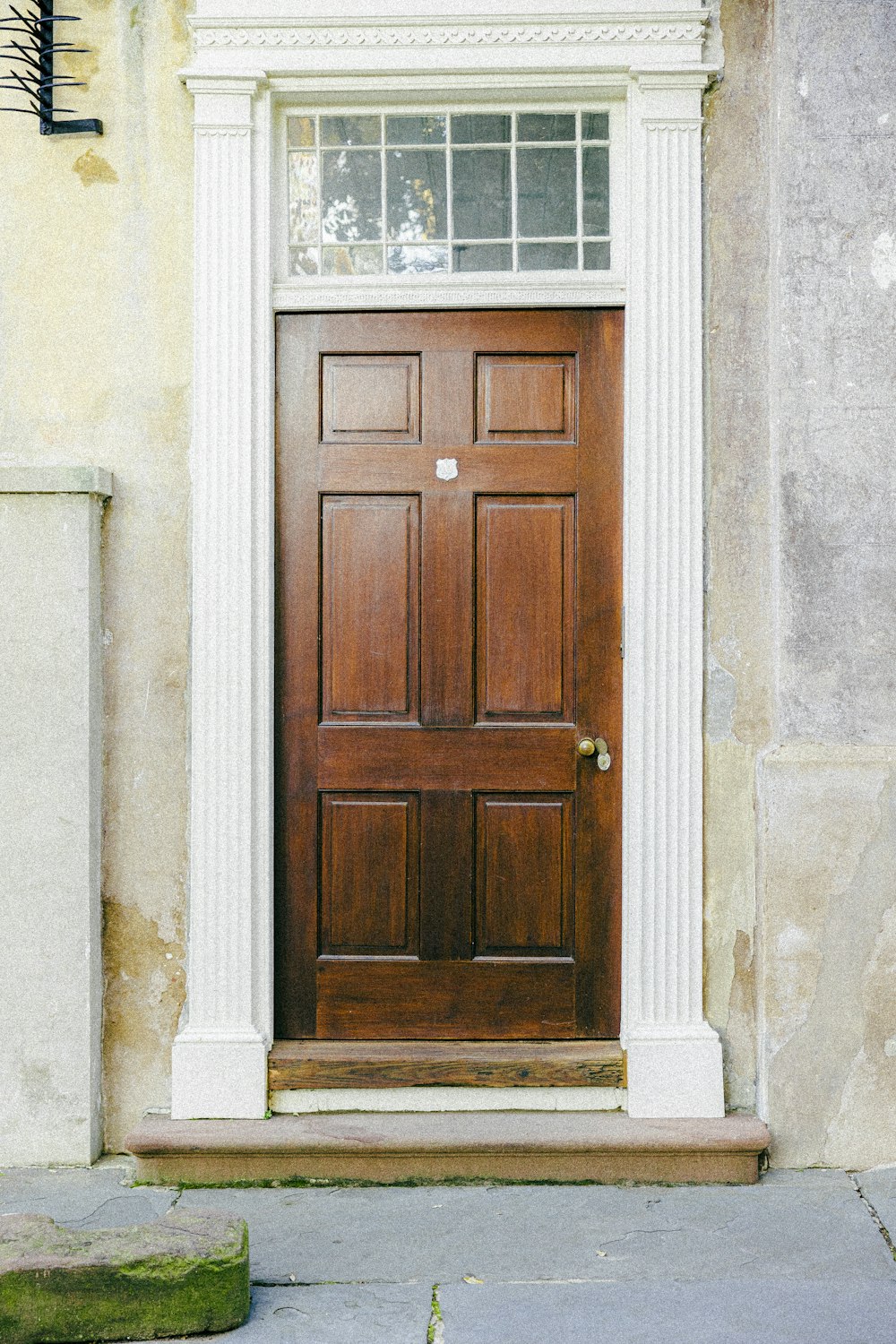 a wooden door on a building with a planter in front of it